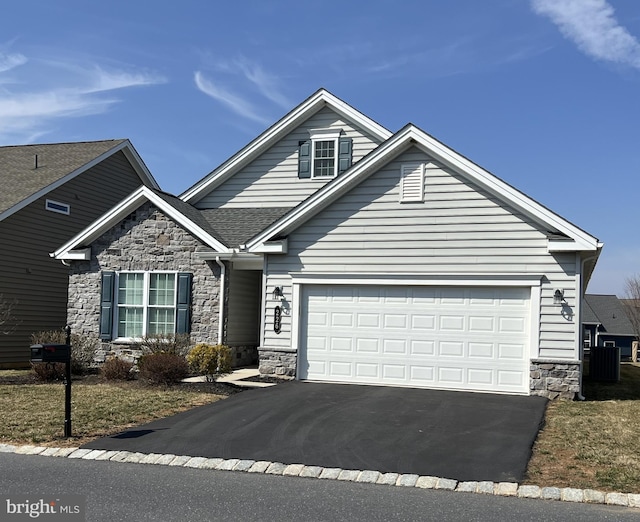 view of front of house featuring a garage, stone siding, driveway, and a shingled roof