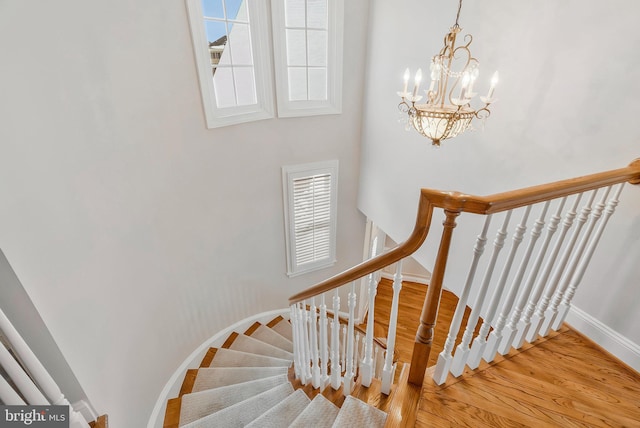 staircase featuring a notable chandelier and hardwood / wood-style flooring