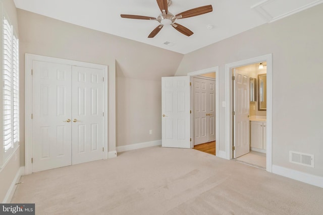 unfurnished bedroom with multiple windows, light colored carpet, a closet, and lofted ceiling