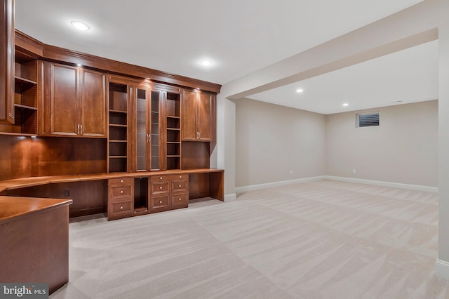 unfurnished office with built in desk and light colored carpet