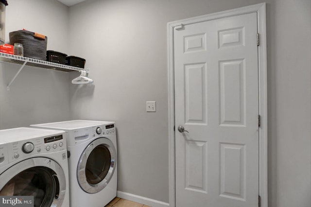 washroom featuring light tile patterned floors and washing machine and clothes dryer