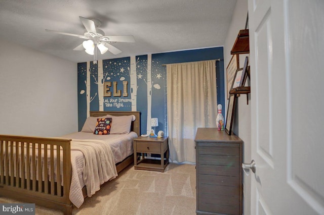 carpeted bedroom with ceiling fan and a textured ceiling