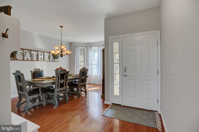 foyer entrance featuring light hardwood / wood-style flooring and a notable chandelier