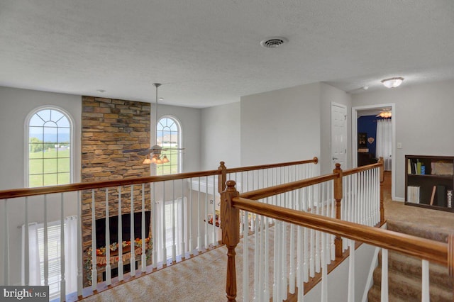 hall with carpet flooring and a textured ceiling