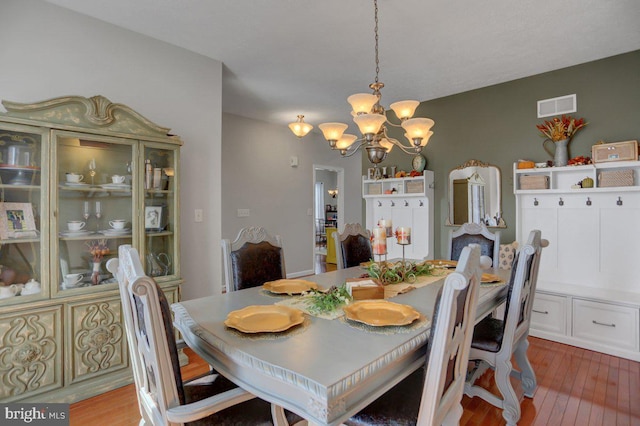 dining room with hardwood / wood-style floors and a chandelier