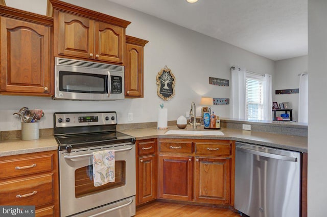 kitchen featuring sink, light wood-type flooring, and stainless steel appliances