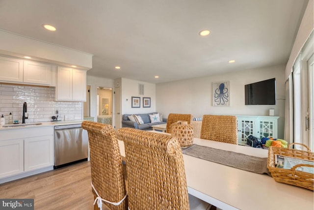 dining room featuring sink and light hardwood / wood-style flooring