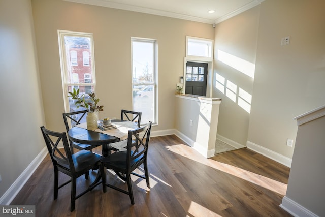 dining space featuring dark hardwood / wood-style flooring, a wealth of natural light, and ornamental molding