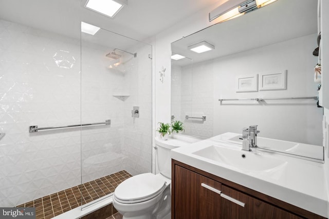 bathroom featuring vanity, toilet, and tiled shower