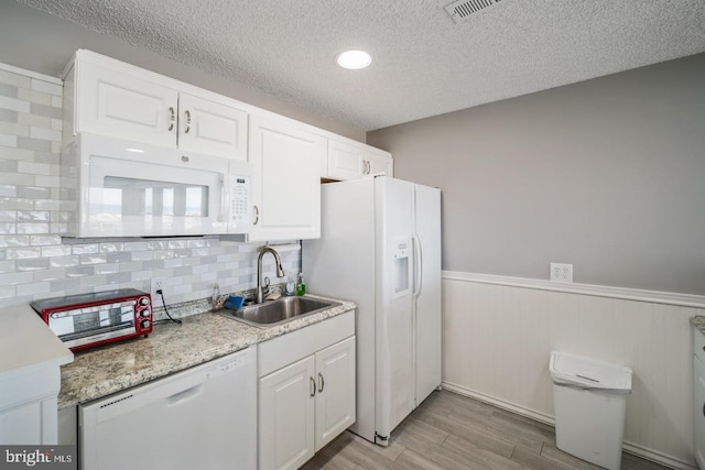 kitchen featuring a textured ceiling, white appliances, sink, light hardwood / wood-style flooring, and white cabinetry