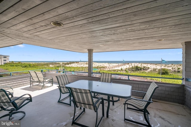 view of patio / terrace featuring a water view and a view of the beach