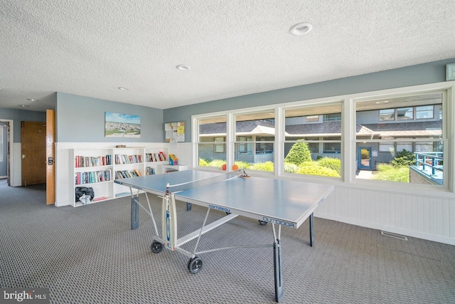 playroom featuring a textured ceiling and carpet floors
