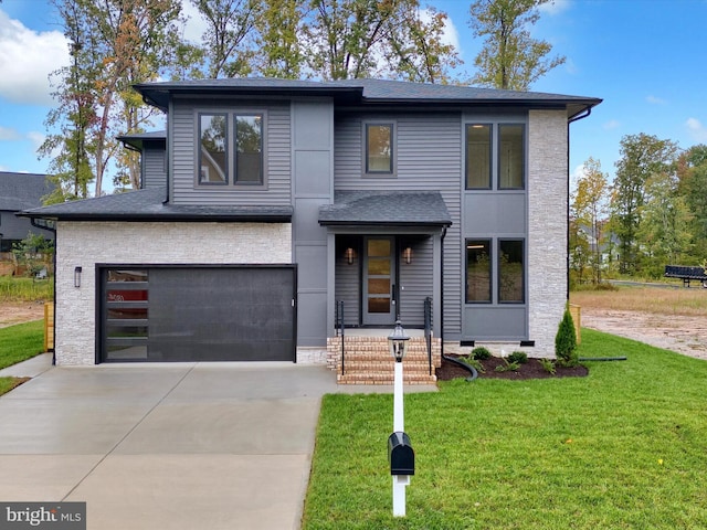 view of front of property featuring a front yard and a garage