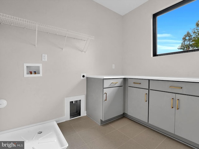 laundry room featuring electric dryer hookup, light tile patterned flooring, cabinets, and hookup for a washing machine