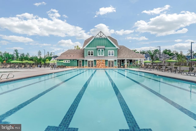 community pool with fence and a patio