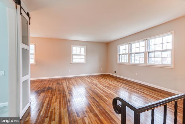 unfurnished room featuring hardwood / wood-style flooring and a barn door