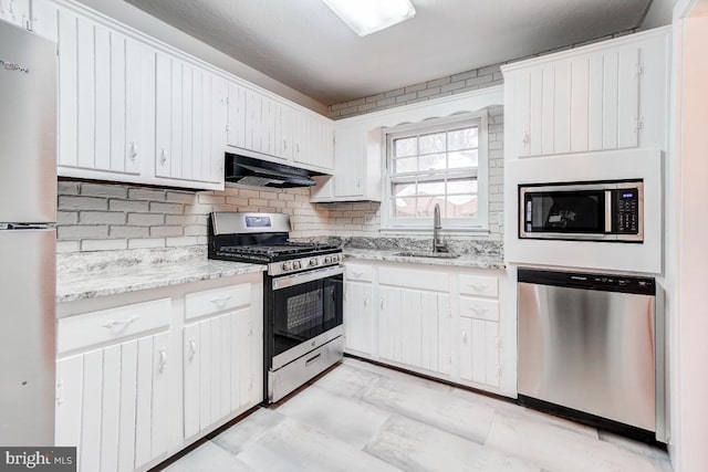 kitchen featuring appliances with stainless steel finishes, white cabinetry, tasteful backsplash, and sink