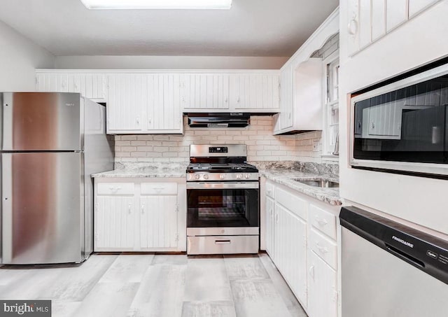 kitchen featuring sink, stainless steel appliances, white cabinetry, and tasteful backsplash