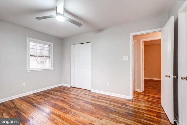 unfurnished bedroom featuring ceiling fan, a closet, and wood-type flooring