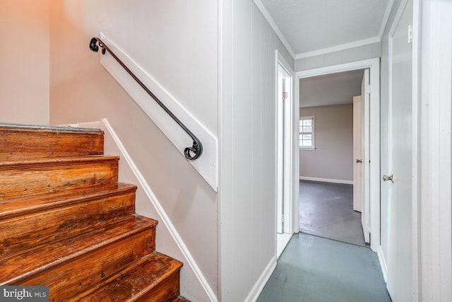 stairway with concrete floors and crown molding