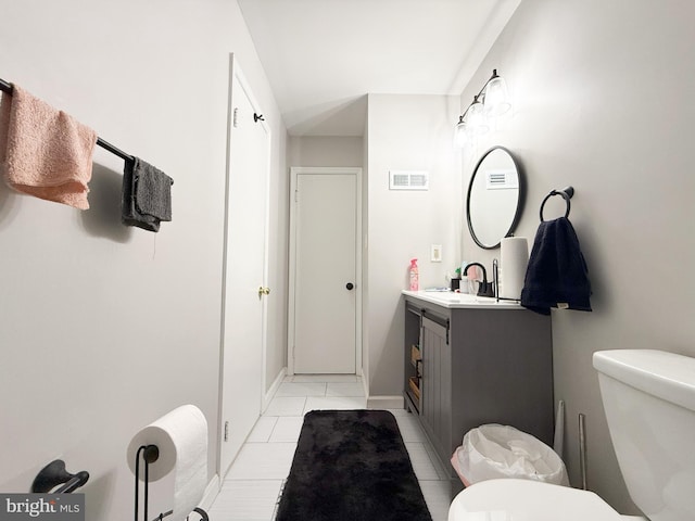 bathroom with toilet, tile patterned flooring, and vanity