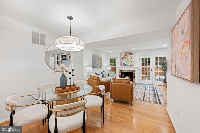 2518 S Walter Reed Dr Unit B, Arlington, VA 22206 - dining space with light wood-style floors, recessed lighting, a brick fireplace, and baseboards