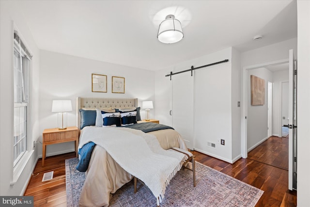 2518 S Walter Reed Dr Unit B, Arlington, VA 22206 - bedroom featuring a barn door, wood finished floors, and baseboards