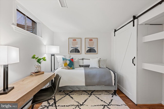 2518 S Walter Reed Dr Unit B, Arlington, VA 22206 - bedroom featuring a barn door, wood finished floors, and baseboards