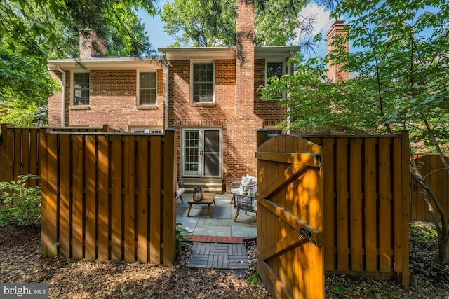 2518 S Walter Reed Dr Unit B, Arlington, VA 22206 - rear view of house with a chimney, brick siding, a gate, and a patio area