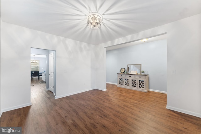 unfurnished living room featuring dark hardwood / wood-style floors and a chandelier