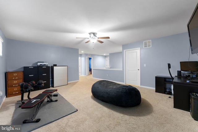 exercise room with ceiling fan and light colored carpet