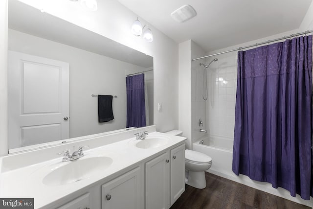 full bathroom with hardwood / wood-style floors, toilet, vanity, and shower / bath combo