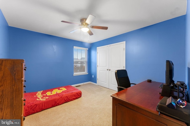 carpeted home office featuring ceiling fan