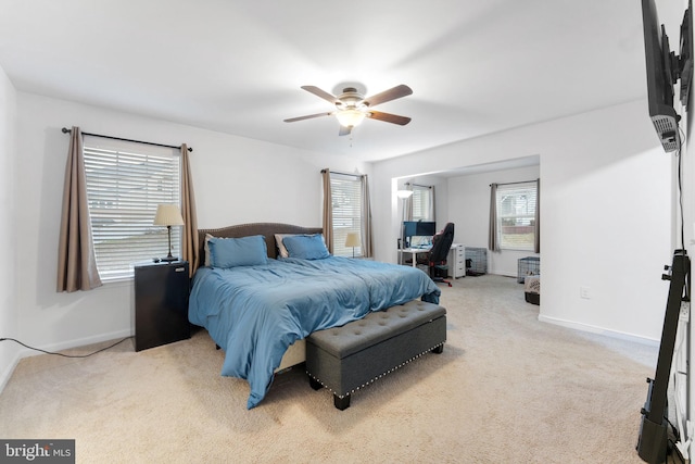 carpeted bedroom with ceiling fan and multiple windows