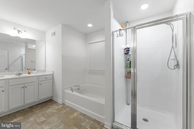 bathroom featuring vanity and independent shower and bath