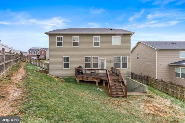 back of house with a deck and a lawn