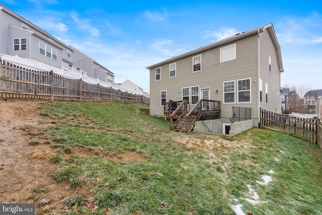 rear view of house with a deck and a yard