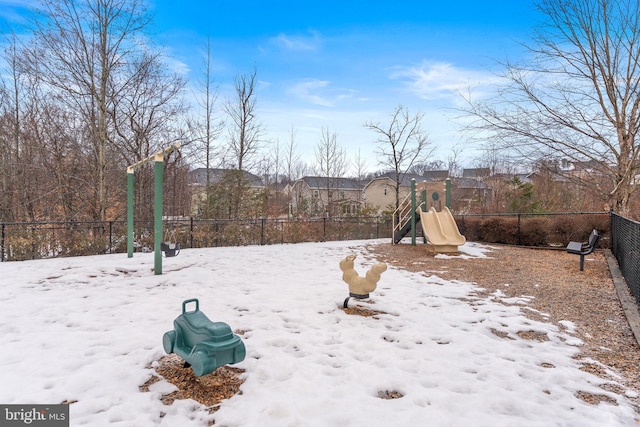 yard covered in snow featuring a playground