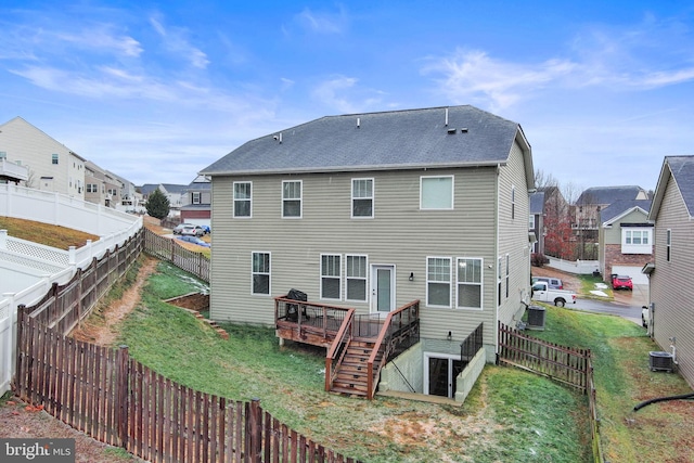 rear view of property with a wooden deck, a yard, and central air condition unit