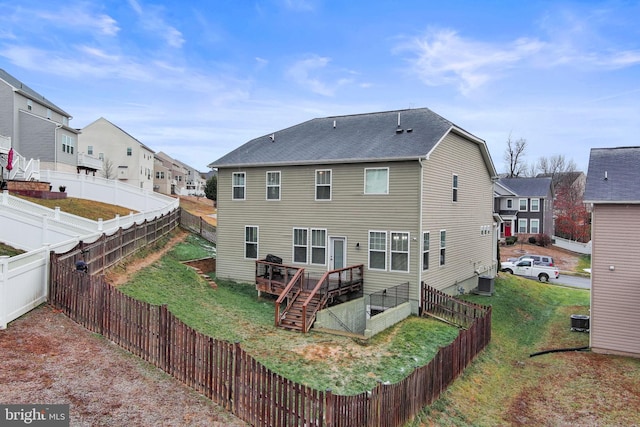 back of property with a deck, a yard, and central AC unit