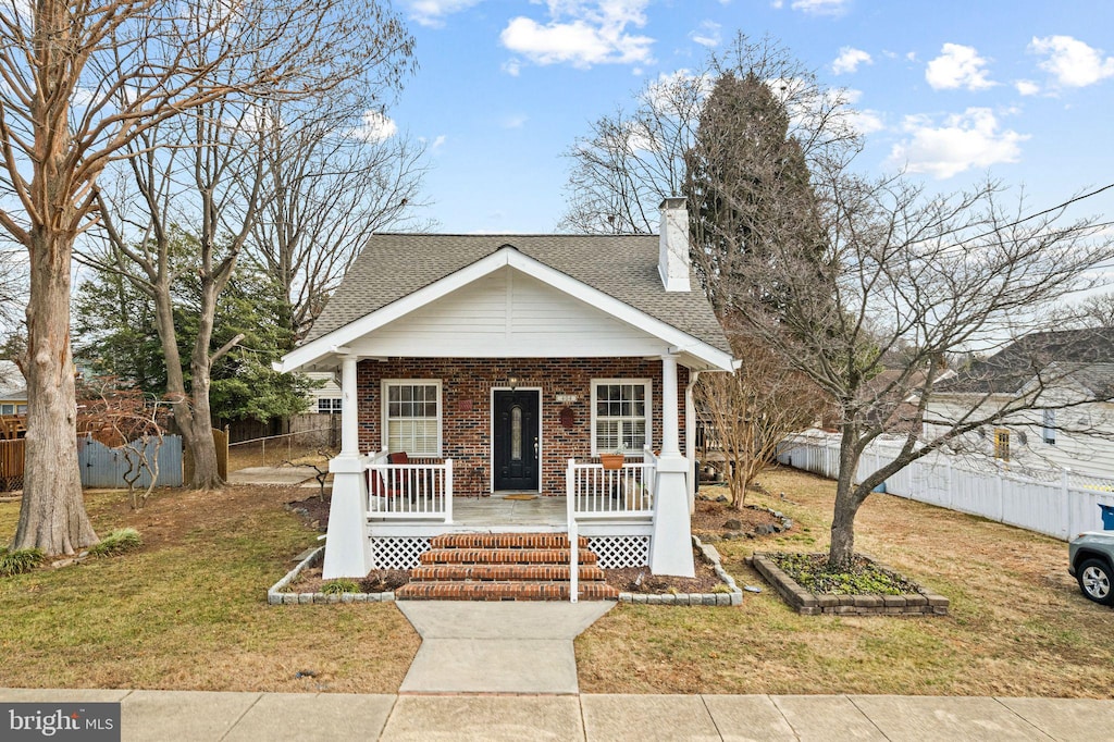 bungalow-style home featuring a porch and a front lawn