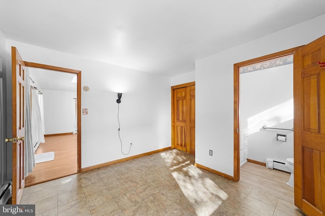 unfurnished bedroom featuring a closet and a baseboard heating unit