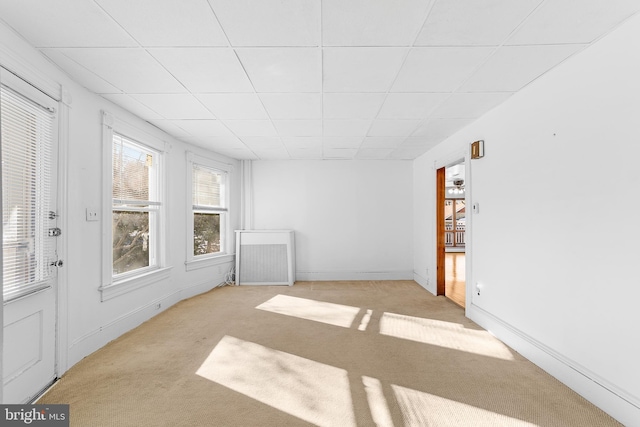 carpeted empty room featuring a paneled ceiling