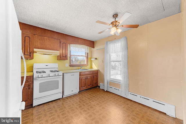 kitchen with a textured ceiling, white appliances, baseboard heating, ceiling fan, and sink