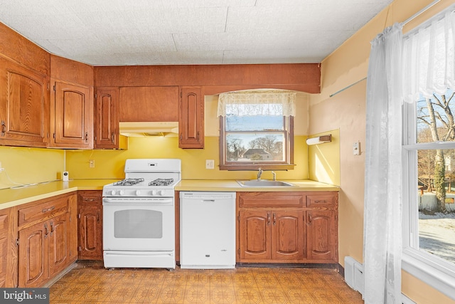 kitchen featuring white appliances, plenty of natural light, and sink