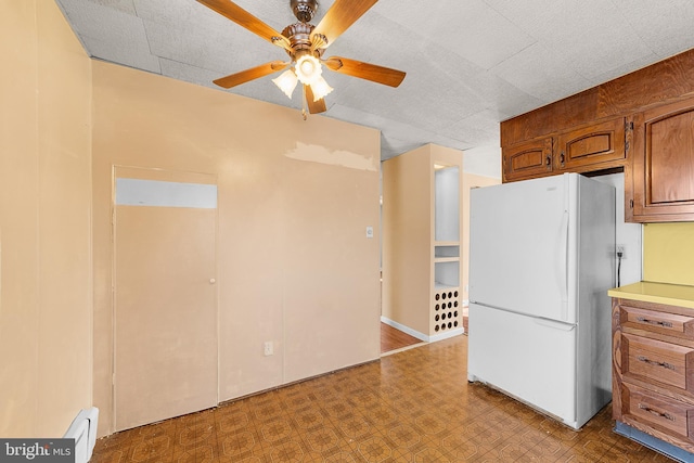 kitchen with white fridge, a baseboard radiator, and ceiling fan