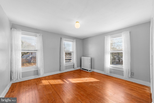 empty room featuring hardwood / wood-style flooring and radiator