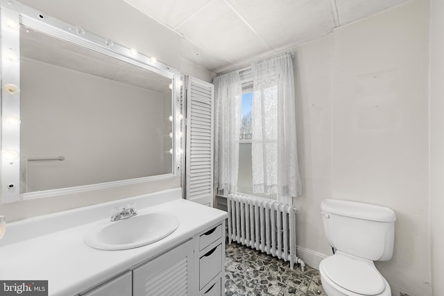 bathroom featuring radiator heating unit, vanity, and toilet