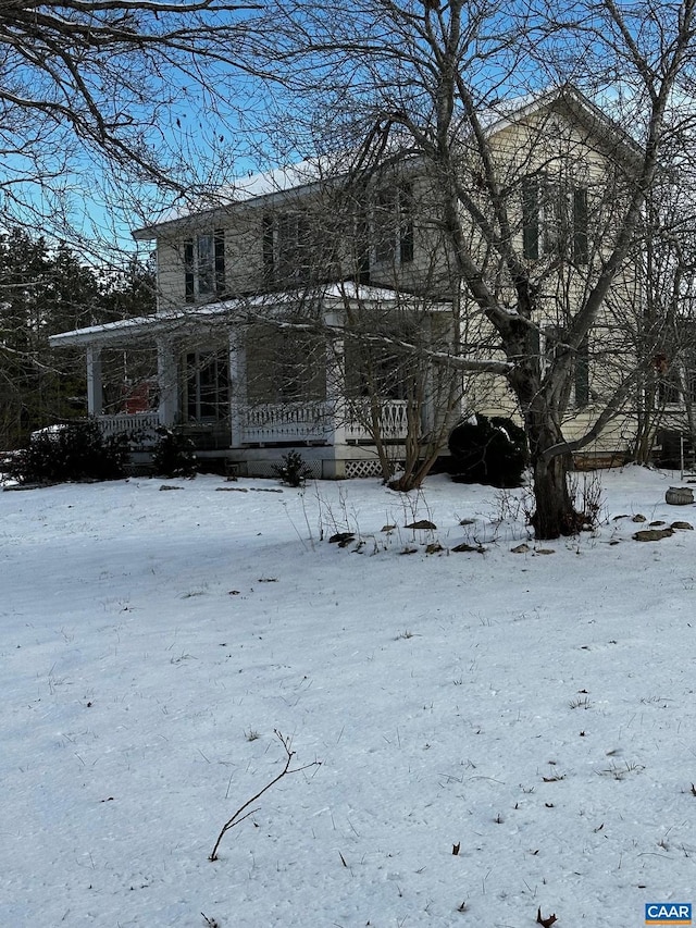 view of snowy exterior featuring a porch