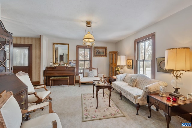 living room with light carpet and a chandelier